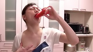 A horny Japanese MILF fucks some food on the kitchen floor